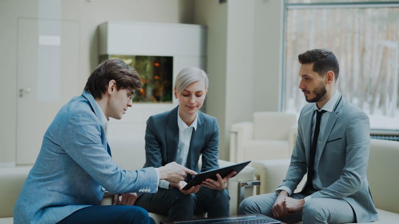 Reunión de trabajo entre tres profesionales en una oficina moderna